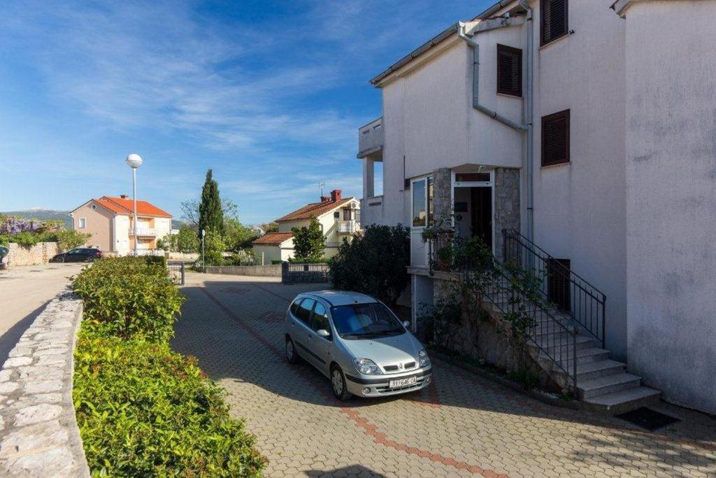 a small car parked next to a white building at Double Room Krk 5294b in Krk