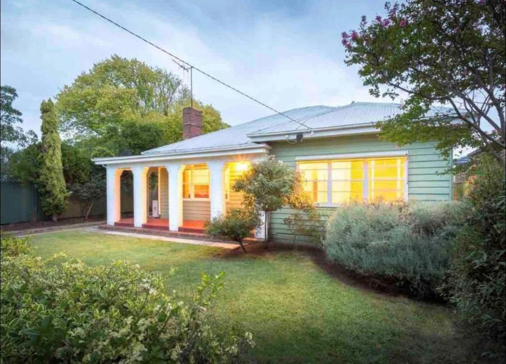 a small white house with a yard at Cheerful 3 bedroom home in the centre of town in Shepparton