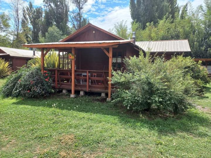 a wooden cabin with a porch in a yard at Villa Rosa House in Pinto