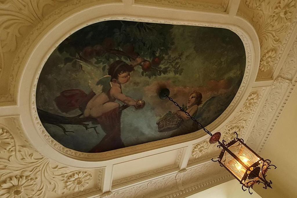 a painting on the ceiling of a room with a lamp at Ferienwohnungen Villa Haniel Carl in Dresden