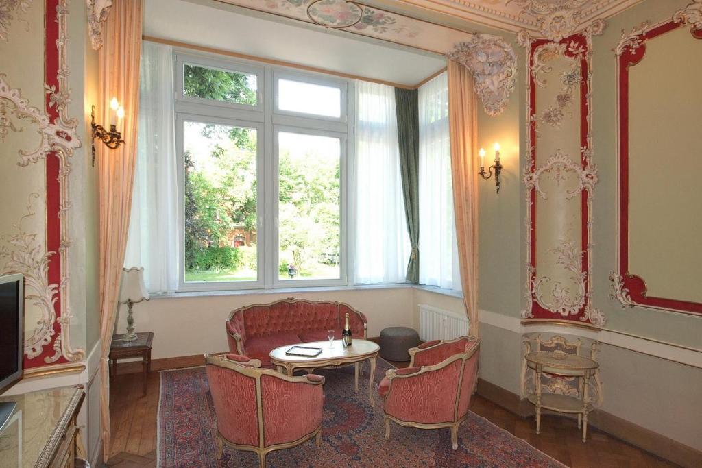 een kamer met een tafel en stoelen en een raam bij Ferienwohnungen Villa Haniel Hugo in Dresden