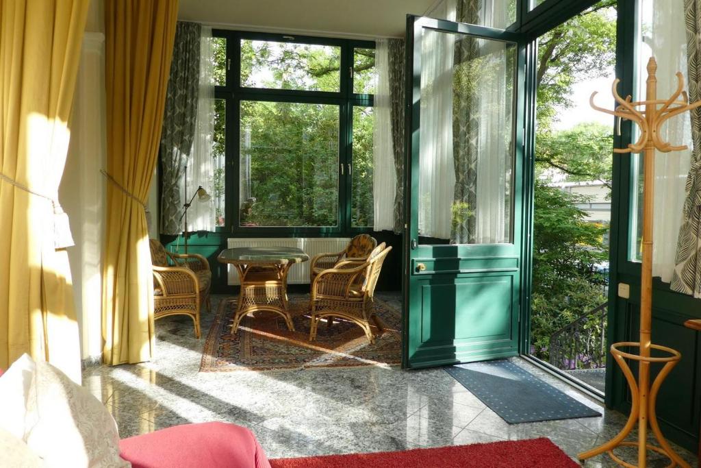 ドレスデンにあるFerienwohnung Villa Haniel Edmundのガラスドア、テーブル、椅子が備わる客室です。
