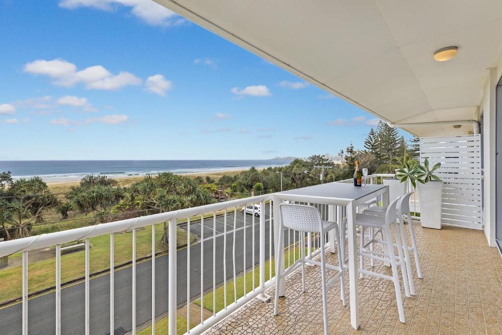 a balcony with a table and chairs and the ocean at Longbeach Unit 12 in Gold Coast