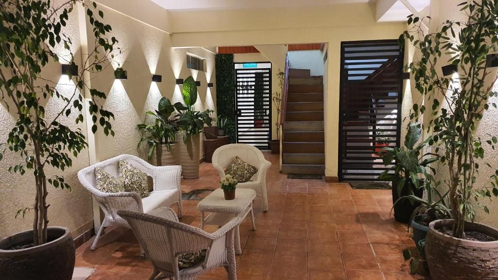 Hostal Costa Brava في إكيكي: غرفة معيشة مع كراسي ونباتات خزفية