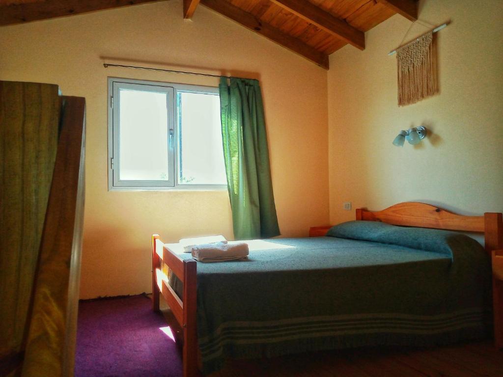 1 dormitorio con cama y ventana en OHANA DEPARTAMENTOS DÚPLEX. en Tandil