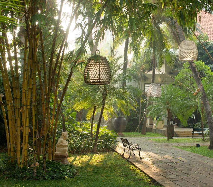 a park with benches and palm trees and lights at Bumi Surabaya City Resort in Surabaya
