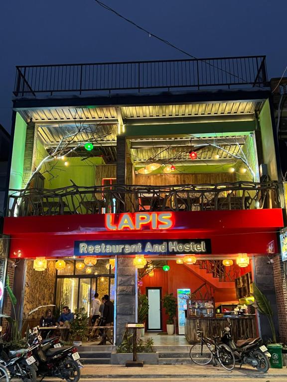 Lapis Restaurant and Hostel في Vũ Lâm: مطعم فيه دراجات ناريه تقف خارجه بالليل