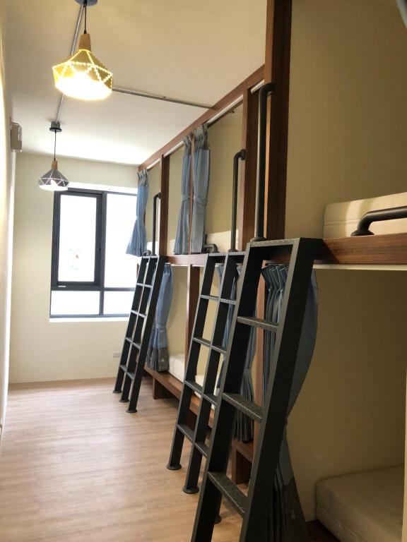 a room with several ladders in a room at Knock Knock Hostel in Kaohsiung