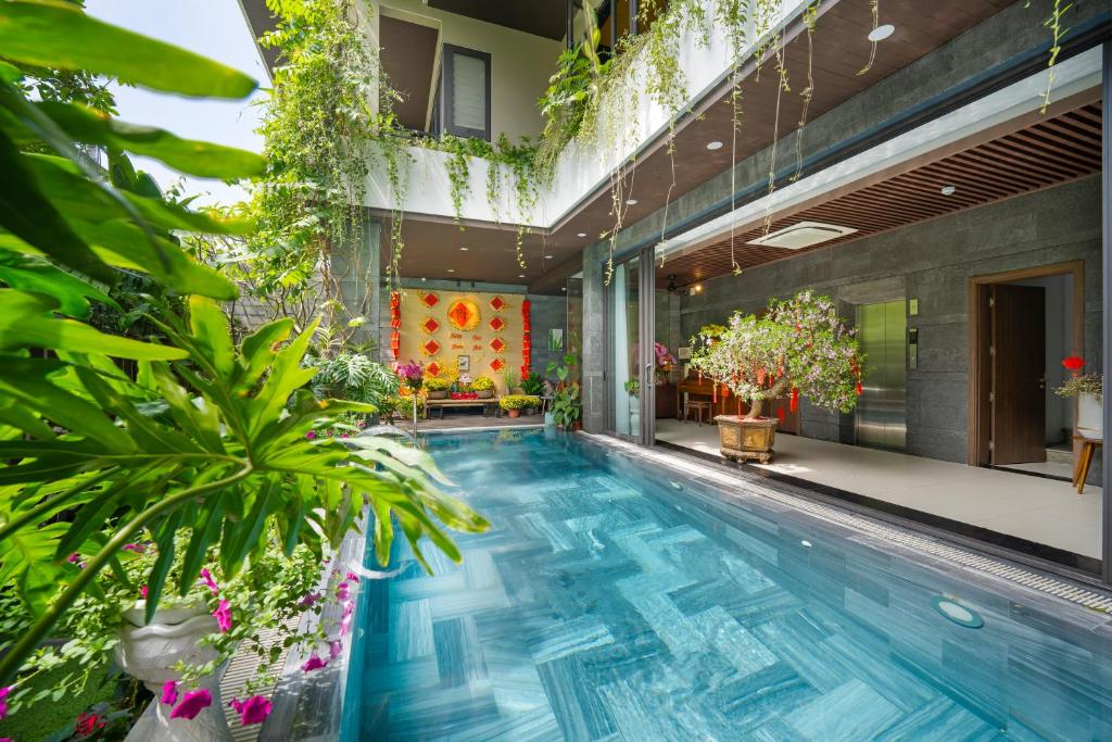 a swimming pool in the middle of a building with plants at Royal 98 Hotel & Apartment in Da Nang