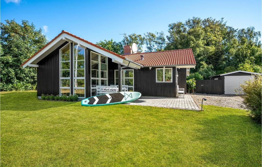 a house with a kayak in the yard at Stunning Home In Allingbro With 3 Bedrooms And Wifi in Allingåbro