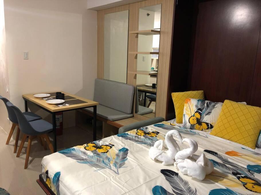 a hotel room with two beds and a table and a desk at Ellie’s Place in Cebu City