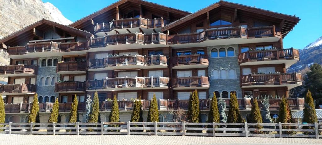 um hotel nas montanhas com árvores em frente em Haus Whymper em Zermatt