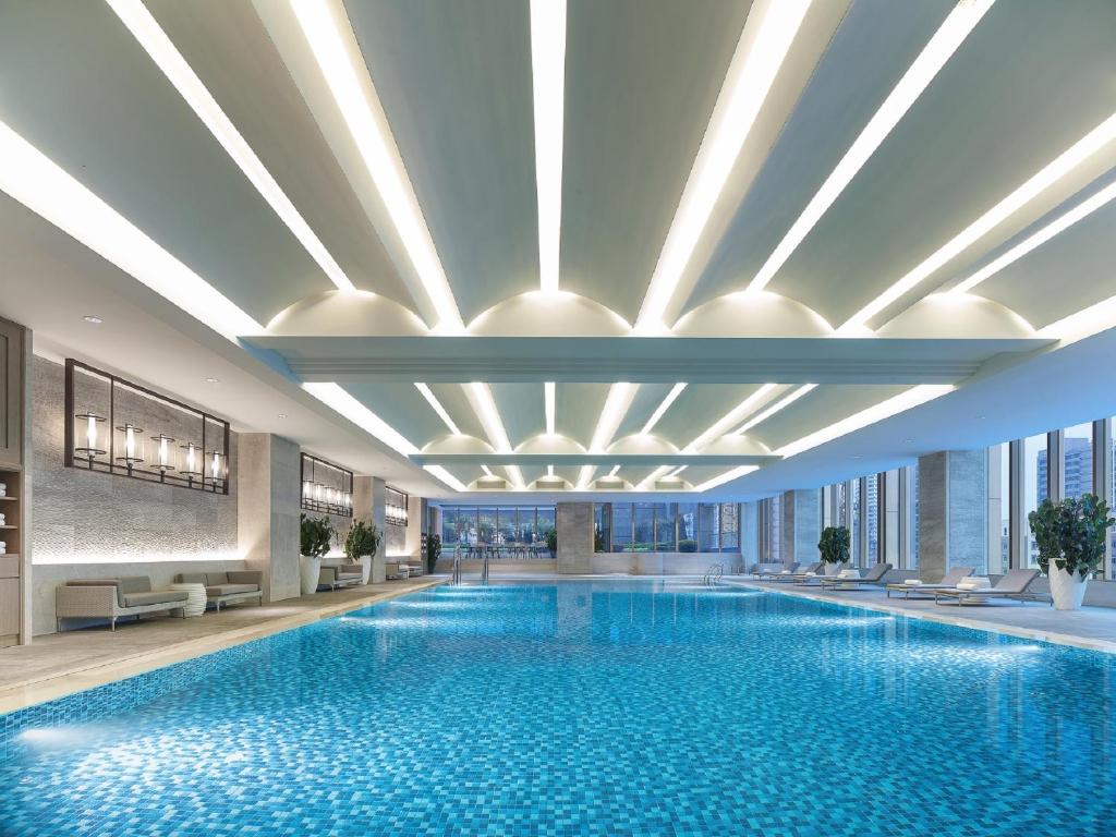 een groot zwembad in een hotel met een groot plafond bij Shangri-La Shenyang in Shenyang