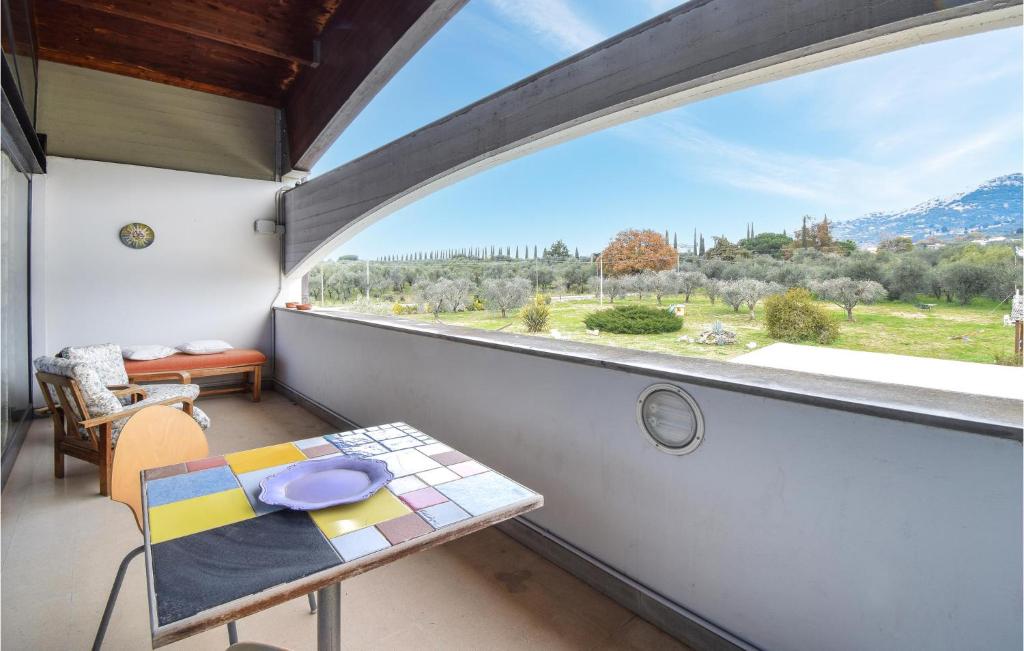 einen Balkon mit einem Tisch und einem großen Fenster in der Unterkunft Awesome Apartment In Cori With Wifi And 2 Bedrooms in Cori