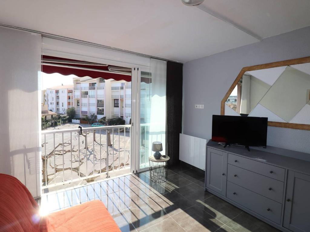 sala de estar con TV y ventana grande en Appartement Le Grau-du-Roi, 2 pièces, 4 personnes - FR-1-307-221 en Le Grau-du-Roi