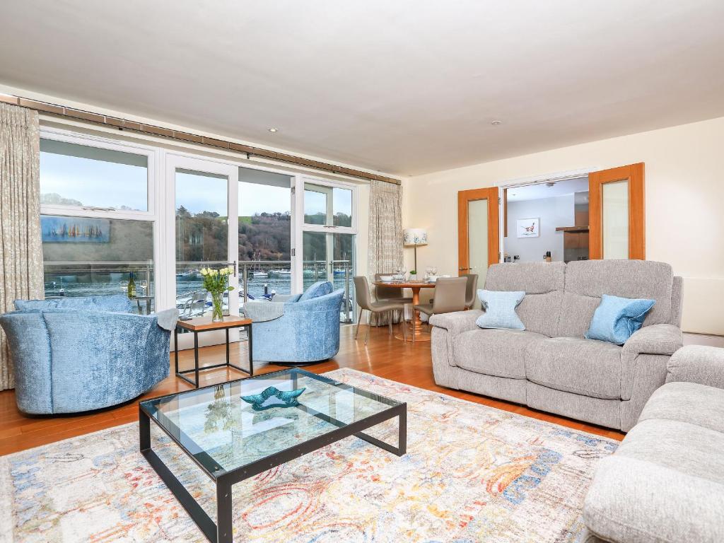 a living room with two couches and a glass table at 15 Dart Marina in Dartmouth