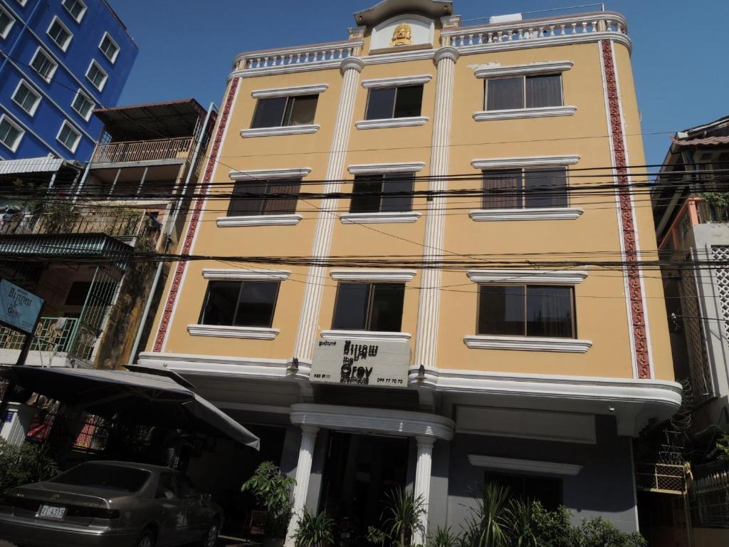 um edifício amarelo com um relógio em cima em The Grey Guesthouse em Phnom Penh