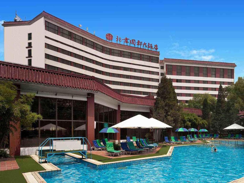un hôtel avec une piscine en face d'un bâtiment dans l'établissement CITIC Hotel Beijing Airport, à Shunyi