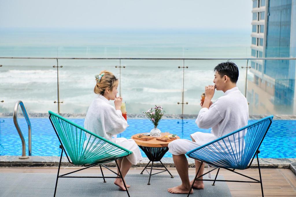 Guests sit beside an elevated pool with an open sea view.