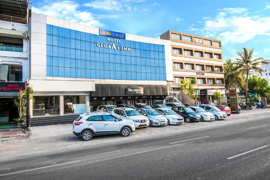 a row of cars parked in front of a building at FabHotel Global Inn I Aurangabad Railway Station in Aurangabad
