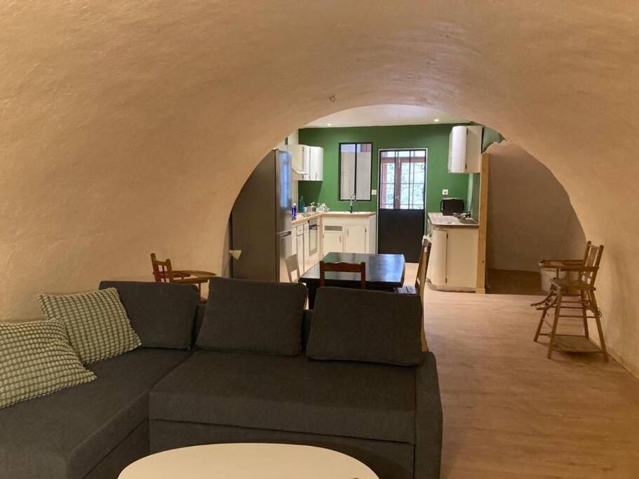 un salon avec un canapé et une cuisine dans l'établissement Appartement Rez-de-chaussée, à Largentière