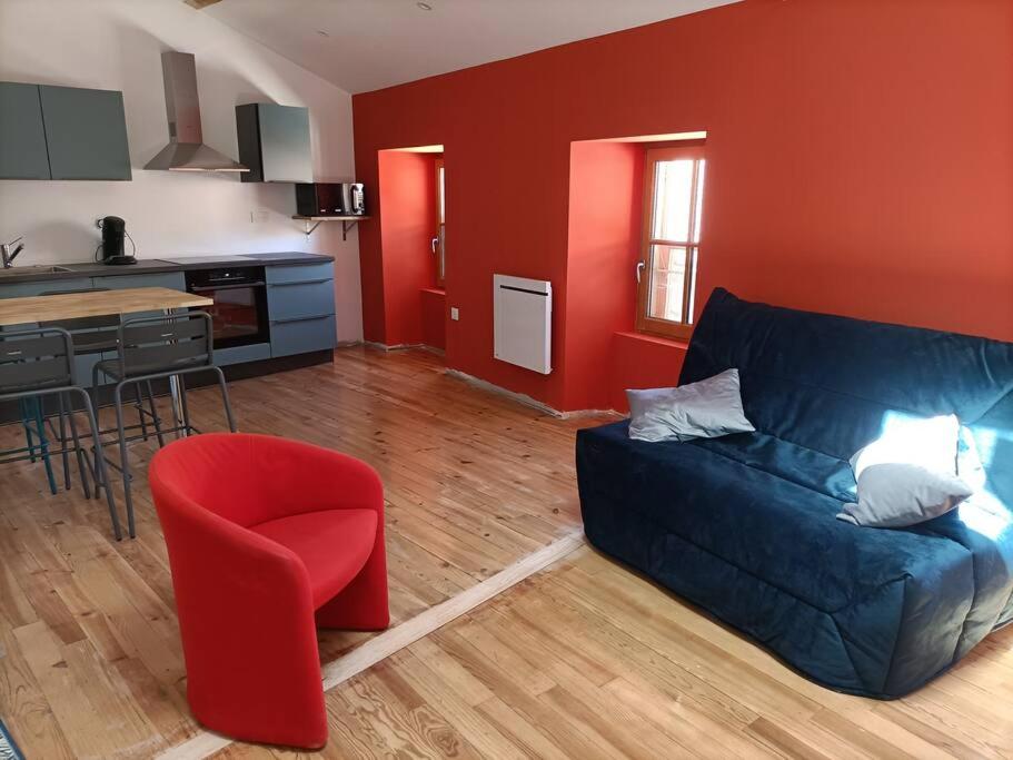 ラルジャンティエールにあるSuperbe appartement au cœur du villageのリビングルーム(青いソファ、赤い壁付)