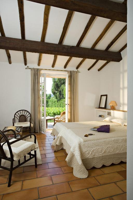 a bedroom with a bed and a chair and a window at Saint-Vincent in Saint-Tropez