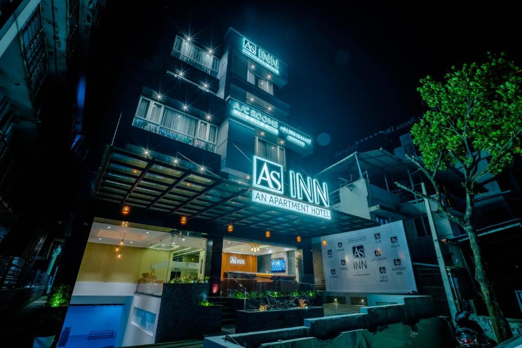 a building with a sign that reads asulum at night at AS Inn in Cochin
