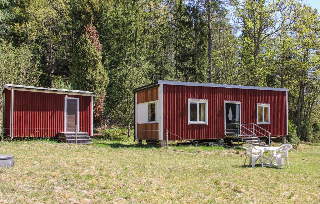 a red tiny house and a table in a field at Holiday home Klåvbensvägen Backaryd III in Backaryd