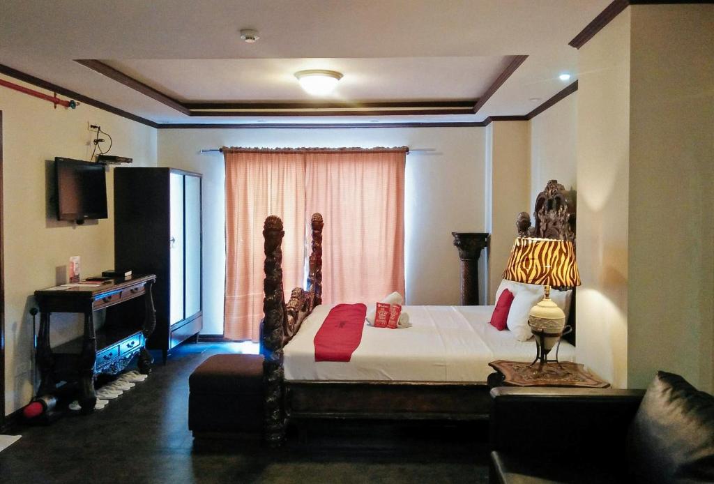 セブシティにあるRedDoorz Plus New Era Budget Hotel Mabolo former RedDoorz near Landers Superstore Cebu Cityのベッドルーム1室(ベッド1台、テーブル、窓付)