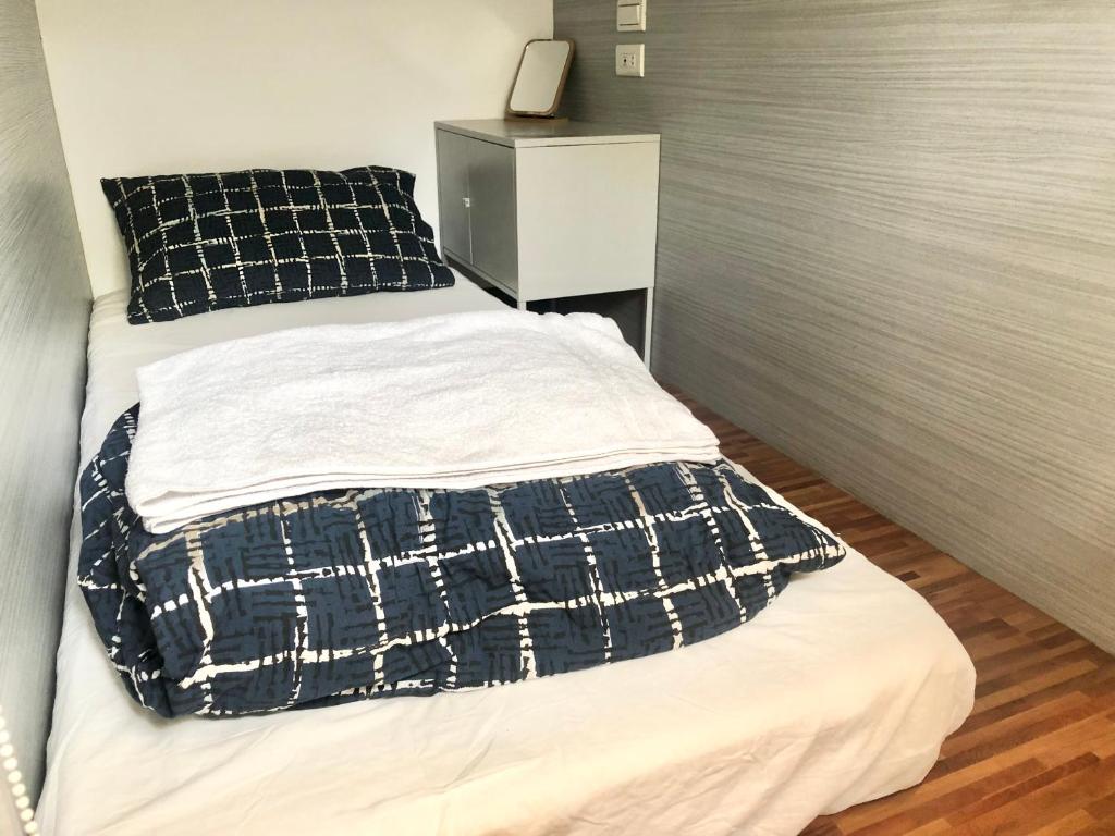 ein Bett mit einer schwarz-weißen Decke drauf in der Unterkunft 不倒翁輕旅 in Hsi-kuo-shan