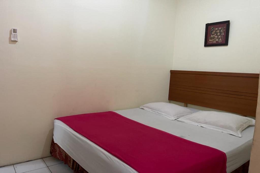 - une chambre dotée d'un lit avec une couverture rouge et blanche dans l'établissement OYO 92342 Hotel Batik Traveller, à Medan