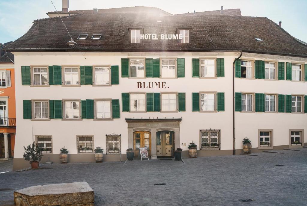 バーデンにあるHotel Blume - Swiss Historic Hotelの緑のシャッターが付いた白い大きな建物