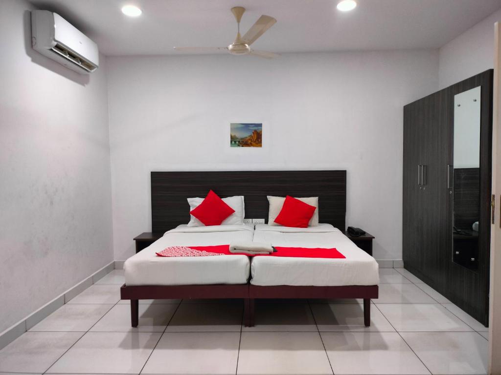 a bedroom with a large bed with red pillows at Kings Fort Rooms Thrippunithura in Ernakulam
