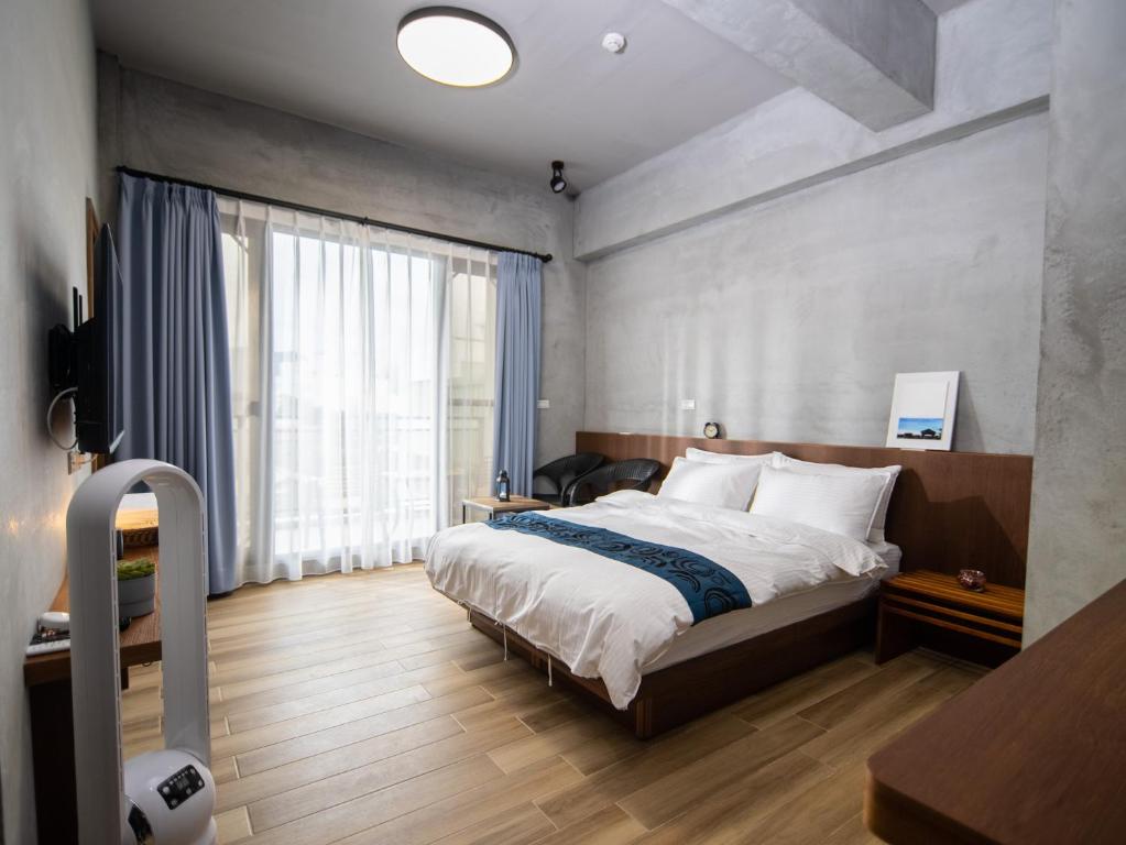 a bedroom with a bed and a large window at 48-6 Homestay in Xincheng