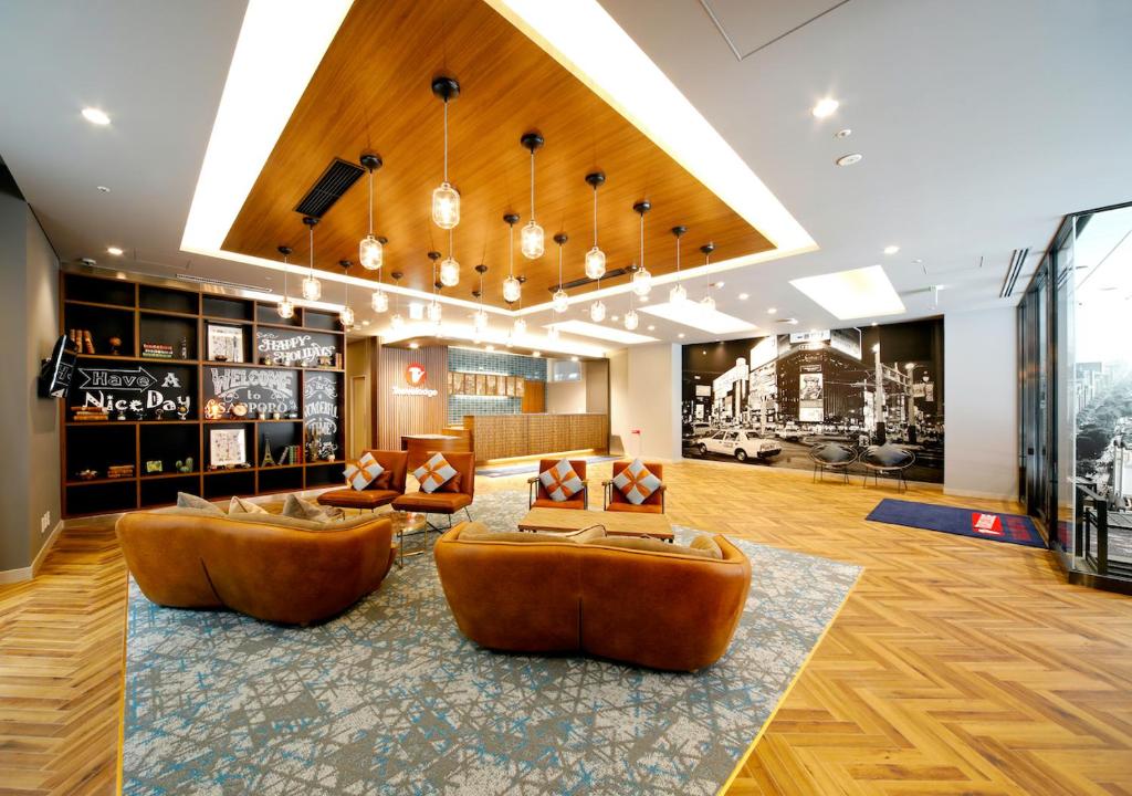 een lobby met banken en stoelen in een gebouw bij Travelodge Sapporo Susukino in Sapporo