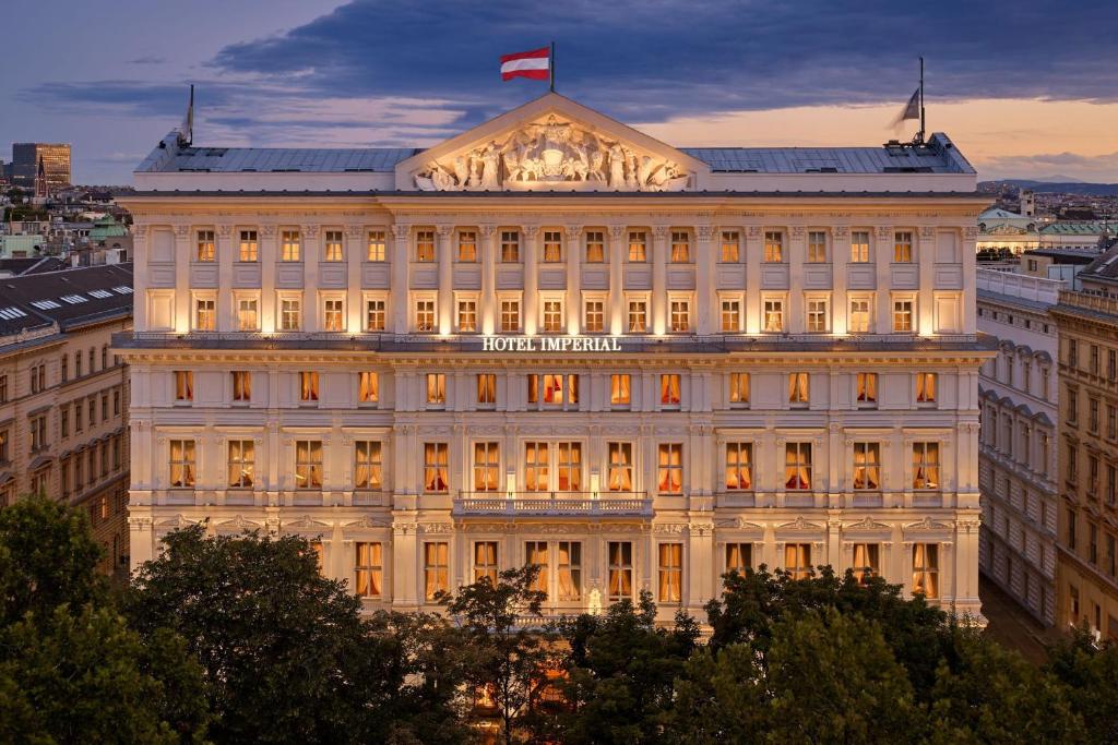 ein Gebäude mit einer Flagge darüber in der Unterkunft Hotel Imperial, a Luxury Collection Hotel, Vienna in Wien