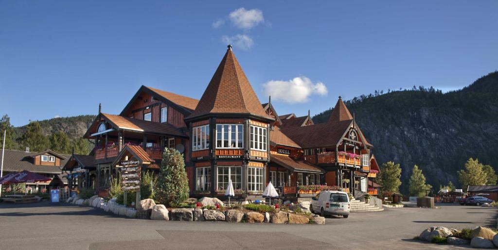 un grand bâtiment marron avec un toit escarpé dans l'établissement Sølvgarden Cottages, à Rysstad