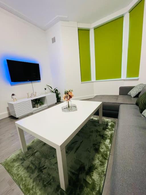 ein Wohnzimmer mit einem weißen Tisch und einem Sofa in der Unterkunft Luxury home in Anfield in Liverpool