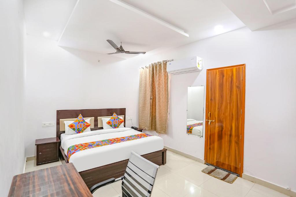 a bedroom with a bed and a table and a chair at FabHotel KS Grand in Kānpur
