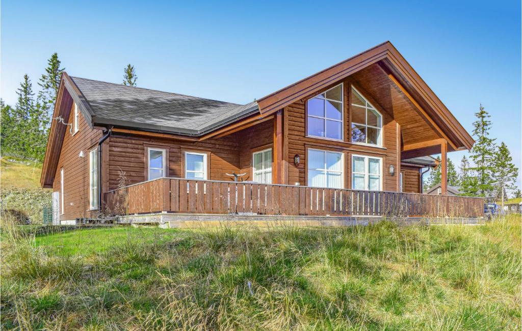 ein Blockhaus mit großer Terrasse auf einem Hügel in der Unterkunft 4 Bedroom Cozy Home In Sjusjøen in Sjusjøen
