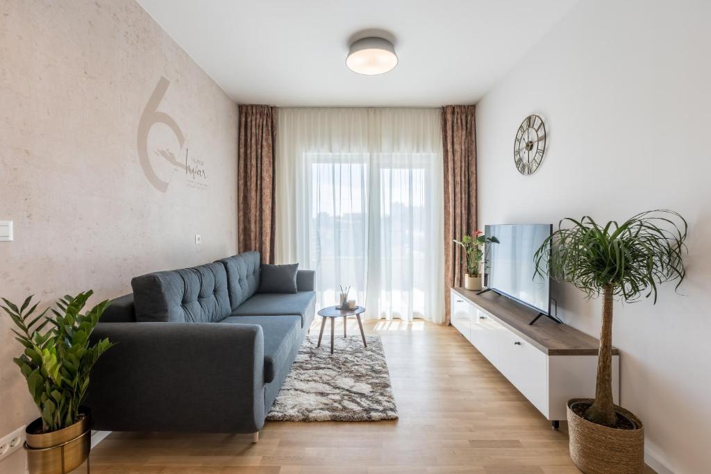 uma sala de estar com um sofá azul e uma televisão em 6 Islands - Holiday & Business Apartments - free garage parking em Split
