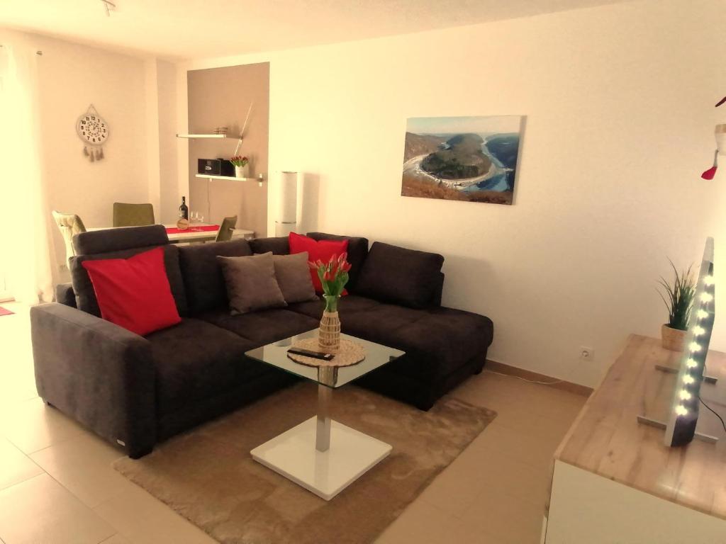 sala de estar con sofá marrón y mesa en Ferienwohnung Am Wolfsweg, en Merzig