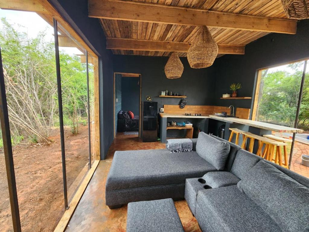 a living room with a couch and a table at Hartbees Eco Bush Lodge 1 in Hartbeespoort