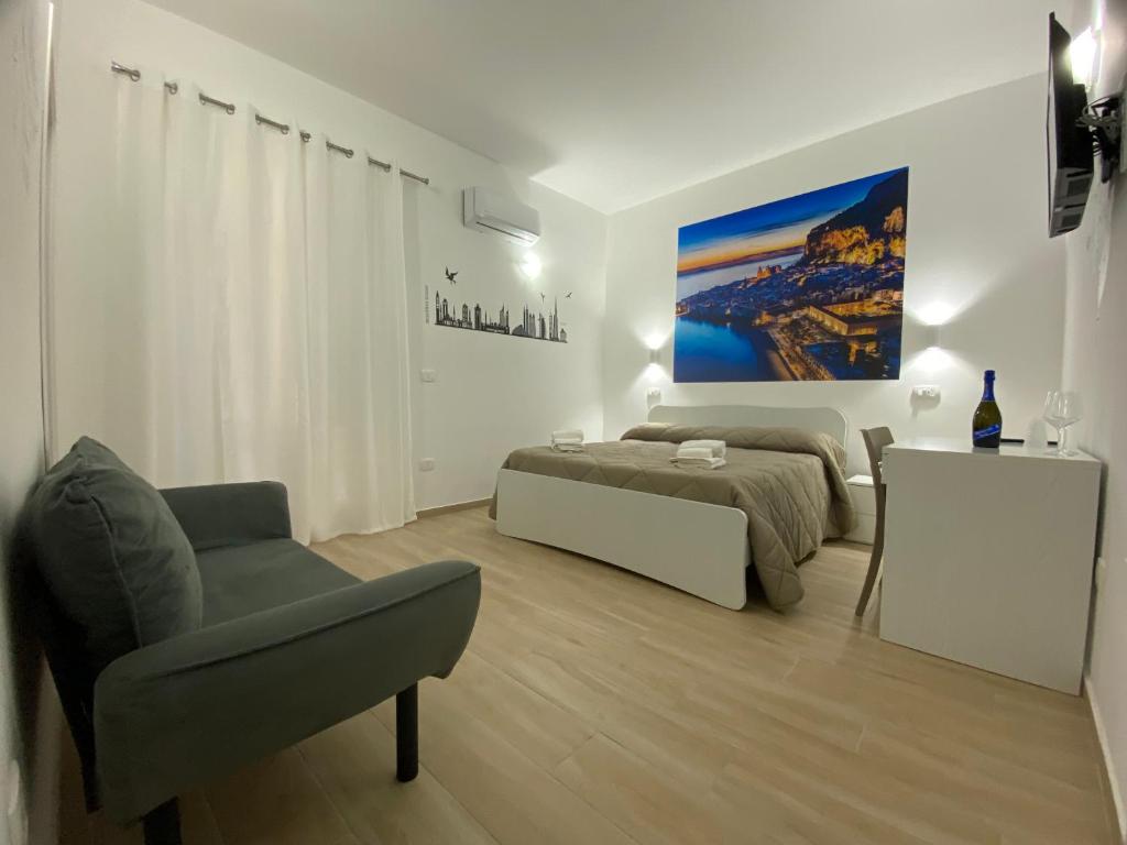 um quarto branco com uma cama e uma cadeira em IN CENTRO ROOMS Vicino Cefalù SELF-CHEK-IN em Campofelice di Roccella