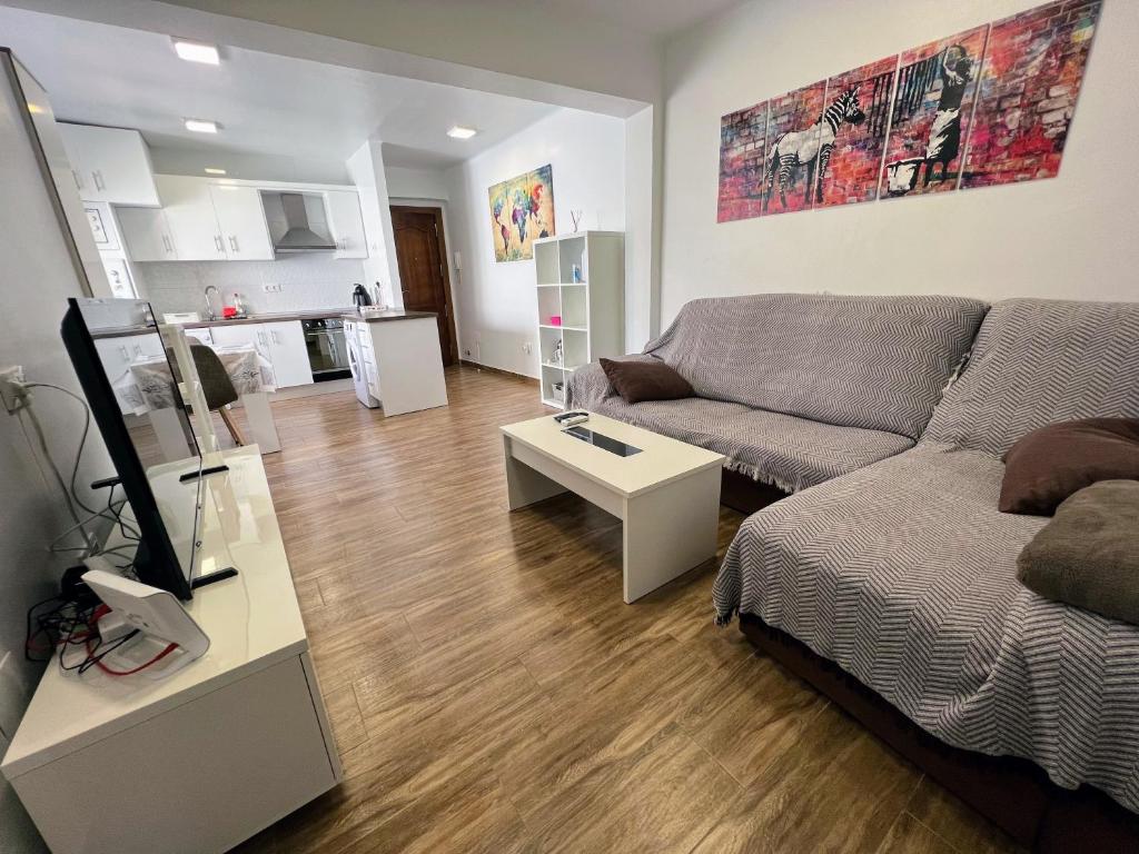 uma sala de estar com um sofá e uma mesa em Apartamento Zapillo a 3 minutos de la playa em Almeria