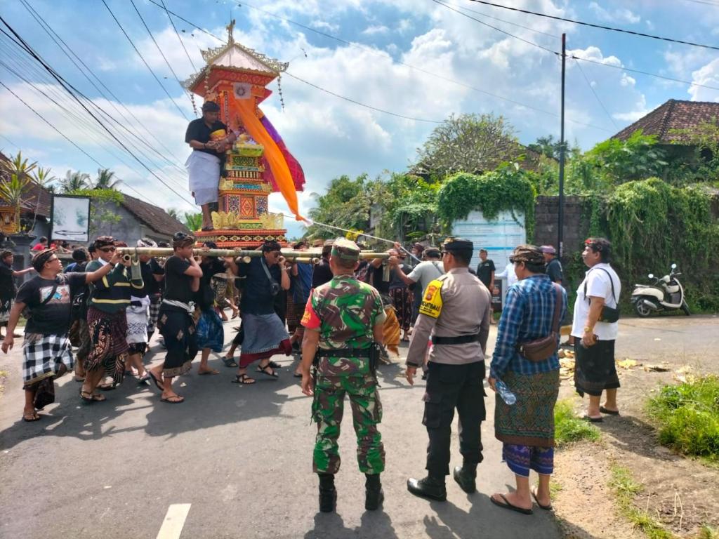 a crowd of people standing in the street watching a parade at Candy home stay in Klungkung