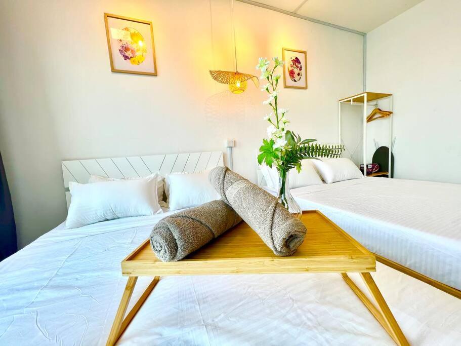 ein Schlafzimmer mit zwei Betten und einem Tisch mit Kissen in der Unterkunft J Cozy 1-5pax Trefoil Setia Alam 100Mps Wifi & TV in Kuala Selangor