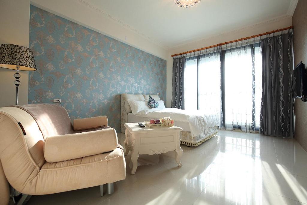 a bedroom with a chair and a bed and a table at Dear B&amp;B in Hualien City