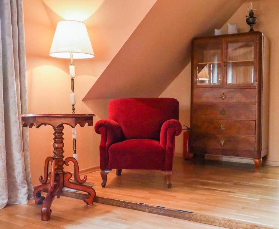 a living room with a red chair and a table at Country house with a pool in Medvednica Nature Park in Zagreb